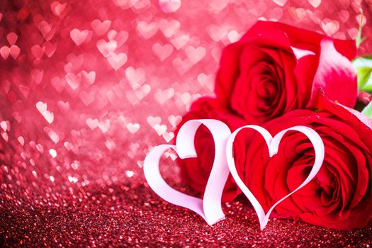 Three red roses and ribbon hearts and over hearts bokeh glittering background