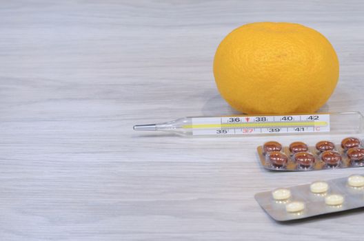 Cold thermometer pills. Flu cure, remedy for convalescence. Photo on a wooden background.