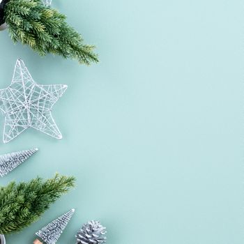 Top view of Christmas holiday decoration ornament composition with Christmas tree, gift star, gingerbread man flat lay with copy space isolated on green background.