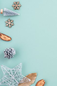 Top view of Christmas holiday decoration ornament composition with Christmas tree, gift star, gingerbread man flat lay with copy space isolated on green background.