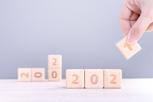 2021 New Year abstract design concept - Number wood block cubes isolated on wooden table and light mist blue background.
