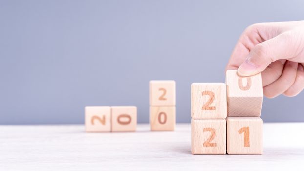 2021 New Year abstract design concept - Number wood block cubes isolated on wooden table and light mist blue background.