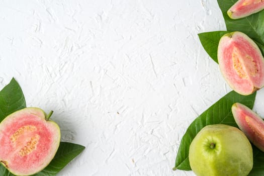 Top view, flat lay of delicious beautiful Red guava with fresh green leaves isolated on white table background, studio overhead table shot with copy space.