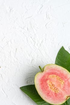 Top view, flat lay of delicious beautiful Red guava with fresh green leaves isolated on white table background, studio overhead table shot with copy space.