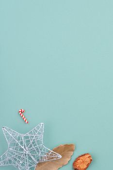 Top view of Christmas holiday decoration ornament composition with Christmas tree, gift star, gingerbread man flat lay with copy space isolated on green background.
