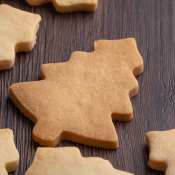 Close up of plain flavor gingerbread Christmas tree cookie on wooden table background. Food for Christmas holiday celebration.