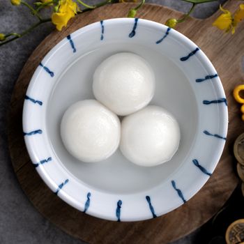 Top view of big tangyuan yuanxiao (glutinous rice dumpling balls) for lunar new year festival food, words on the golden coin means the Dynasty name it made.