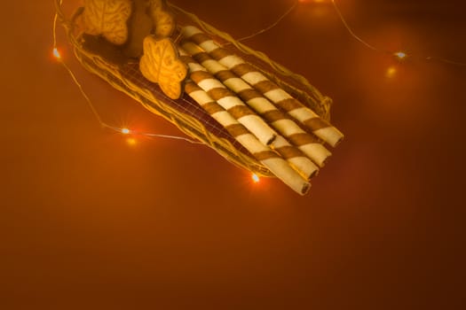 Tubes of cream in a basket and an orange-brown background, top view