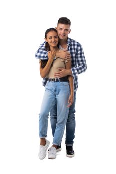 Smiling young couple embracing and standing full length isolated on white background