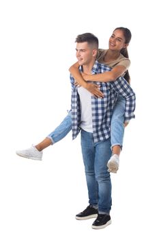 Young happy couple with her at piggyback ride isolated on white background, casual people