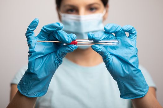 Medical healthcare nurse holding Coronavirus COVID-19 swab test kit, PPE protective mask and gloves, tube for taking OP NP patient specimen sample, PCR DNA RNA testing protocol process stock photo