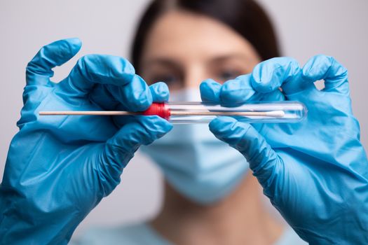 Medical healthcare nurse holding Coronavirus COVID-19 swab test kit, PPE protective mask and gloves, tube for taking OP NP patient specimen sample, PCR DNA RNA testing protocol process stock photo