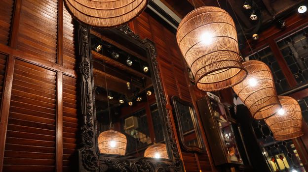 Lamps reflecting in the mirror inside restaurant. Vintage lamp in restaurant. Close up of lamp in restaurant. Indoor decoration. Interior lights.