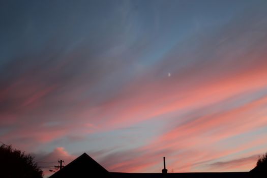 Fire sunset with hazy clouds and house