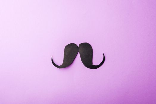 Black mustache paper, studio shot isolated on purple background, Prostate cancer awareness month, Fathers day, minimal November moustache concept