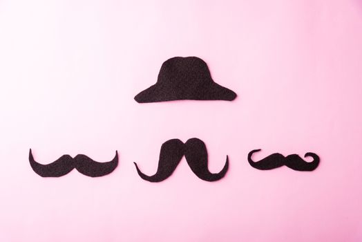 Black mustache and cap, studio shot isolated on pink background, Prostate cancer awareness month, Fathers day, minimal November moustache concept