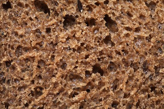 Extreme closeup of slice of rye bread as background