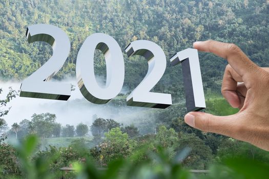 People man hand holding numbers 2021 Metaphor In the new year 2021 festival With scenic scenery In the forest Mountain and fog of Khao Kho Phetchabun Thailand Count down change 2020 to 2021 year