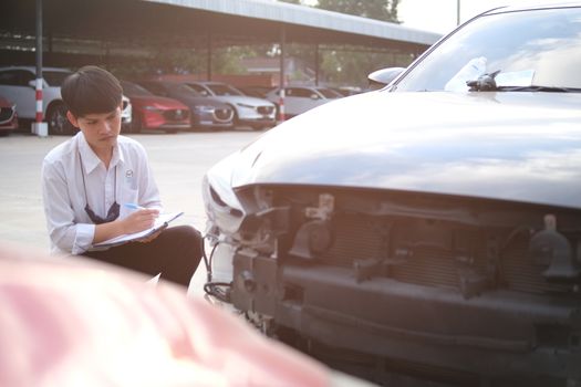 Asian saleman inspector checking writing on clipboard change wheels in garage of dealership mechanic In showroom car and insurance for check to travel to happy new year 2021