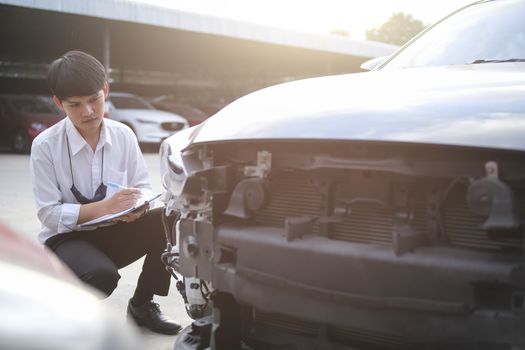 Asian saleman inspector checking writing on clipboard change wheels in garage of dealership mechanic In showroom car and insurance for check to travel to happy new year 2021