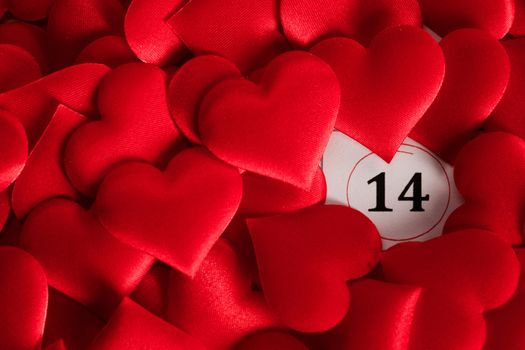 Valentine's day red silk hearts on calendar with 14 february date background, love, celebration concept