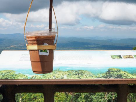 A glass of Thai tea on a mountain background in Khao Yai National Park