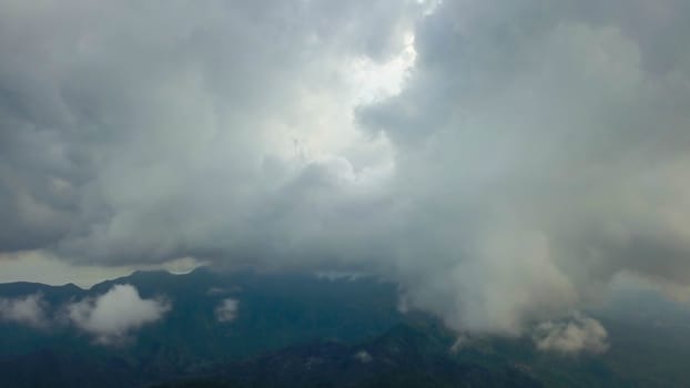 Stormy clouds in a blue sky over the mountains.