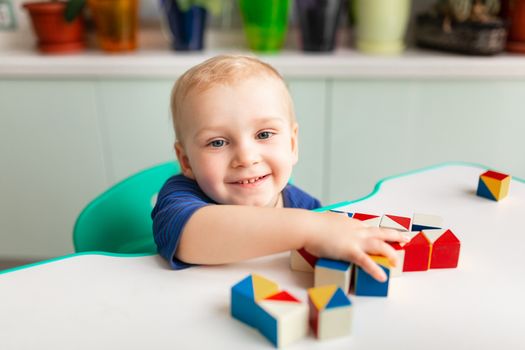 Baby playing with wooden blocks creating a pattern. Nikitin unicube game