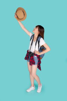 Beautiful portrait young asian woman smiling and holding hat and camera travel summer trip in vacation isolated on blue background, tourist asia girl cheerful journey with hobby in holiday concept.