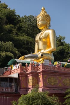 Chiang Rai Thailand 12.10.2015 large seated, crossed leg golden Buddha by river northern Thailand. High quality photo