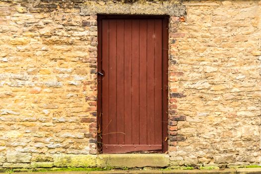 Old wooden door in the stone castle wall. Virton, Belgium