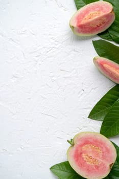Top view, flat lay of delicious beautiful Red guava with fresh green leaves isolated on white table background, studio overhead table shot with copy space.