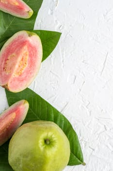 Top view, flat lay of delicious beautiful Red guava with fresh green leaves isolated on white table background, studio overhead table shot with copy space.