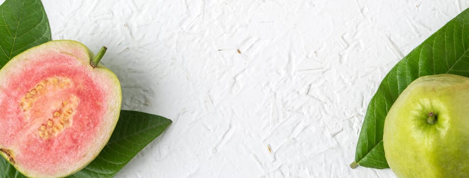 Top view, flat lay of delicious beautiful Red guava with fresh green leaves isolated on white table background, studio overhead table shot with copy space.
