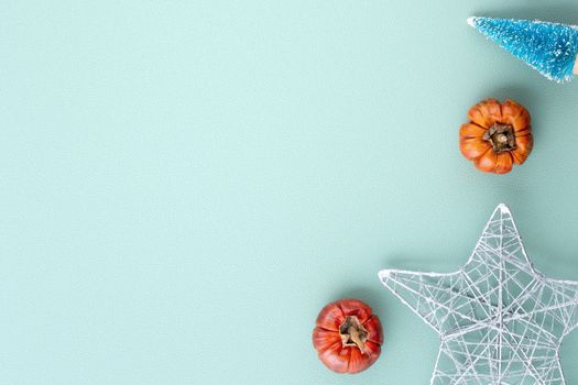 Top view of Christmas holiday decoration ornament composition with Christmas tree, gift star, gingerbread man flat lay with copy space isolated on green background.