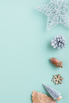 Top view of Christmas holiday decoration ornament composition with Christmas tree, gift star, gingerbread man flat lay with copy space isolated on green background.