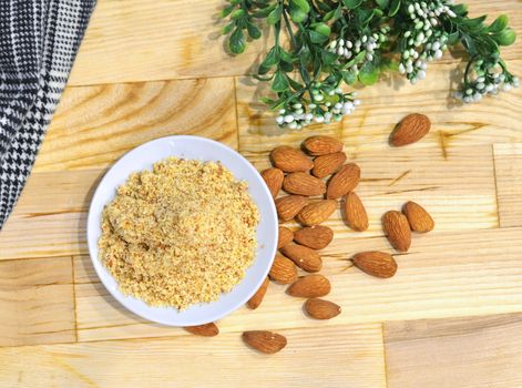 Almond flour pile from top on wooden background.