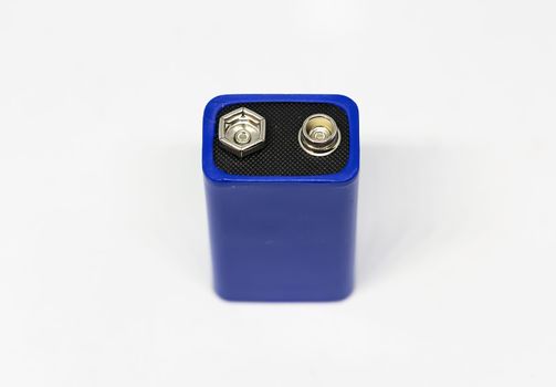 Detail of the positive and negative poles of a blue 9 volt battery isolated on a white background. Electric energy