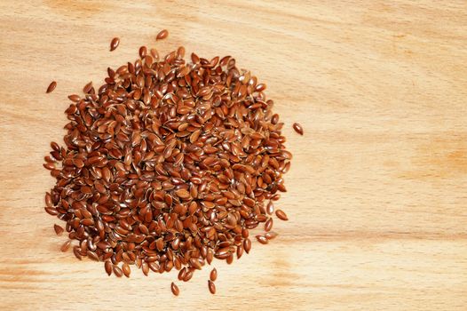 flax seeds on a light wooden background.