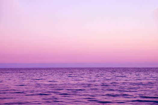 clear sunset sky, sea and skyline in pink tones.