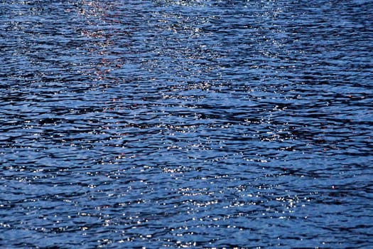 coastal city lights are reflected in sea water.