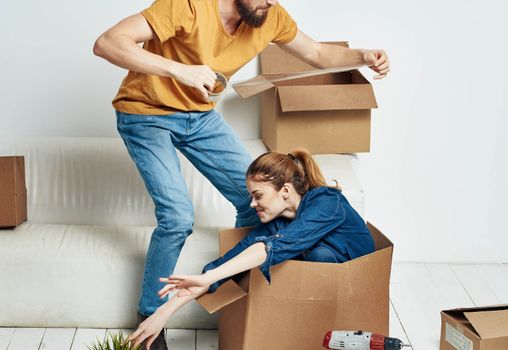 Man and woman in a new apartment boxes with things interior. High quality photo