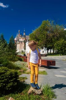 Positive little girlstaying on the big stone trying to keep her balance.