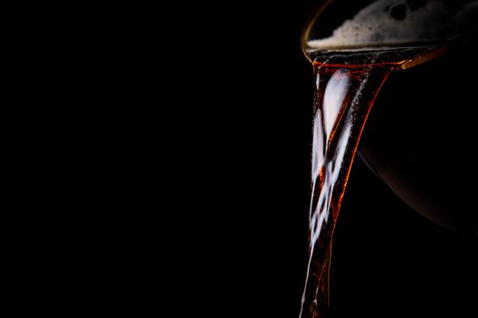 Black beer pouring on a black background
