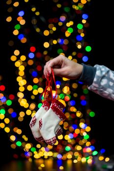 Woman's hands hold christmas decoration. Christmas and New Year holidays background, winter season with Christmas ornaments and blurred lights