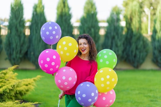 Young bright joyful brunette girl with colorful balloons. Happy lifestyle.