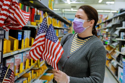 A young woman shopping in a supermarket during a virus epidemic on face under the mask with coronavirus COVID-19