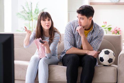 Family pair watching football at home