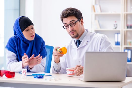 Dentist doctor and assistant working on new tooth implant