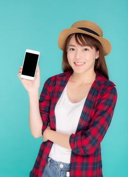 Beautiful young asian woman showing smart mobile phone for presenting something in travel summer trip in vacation isolated on blue background, asia girl holding smartphone, holiday concept.